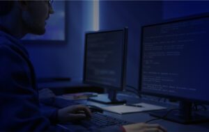 A person working on a computer with two laptops