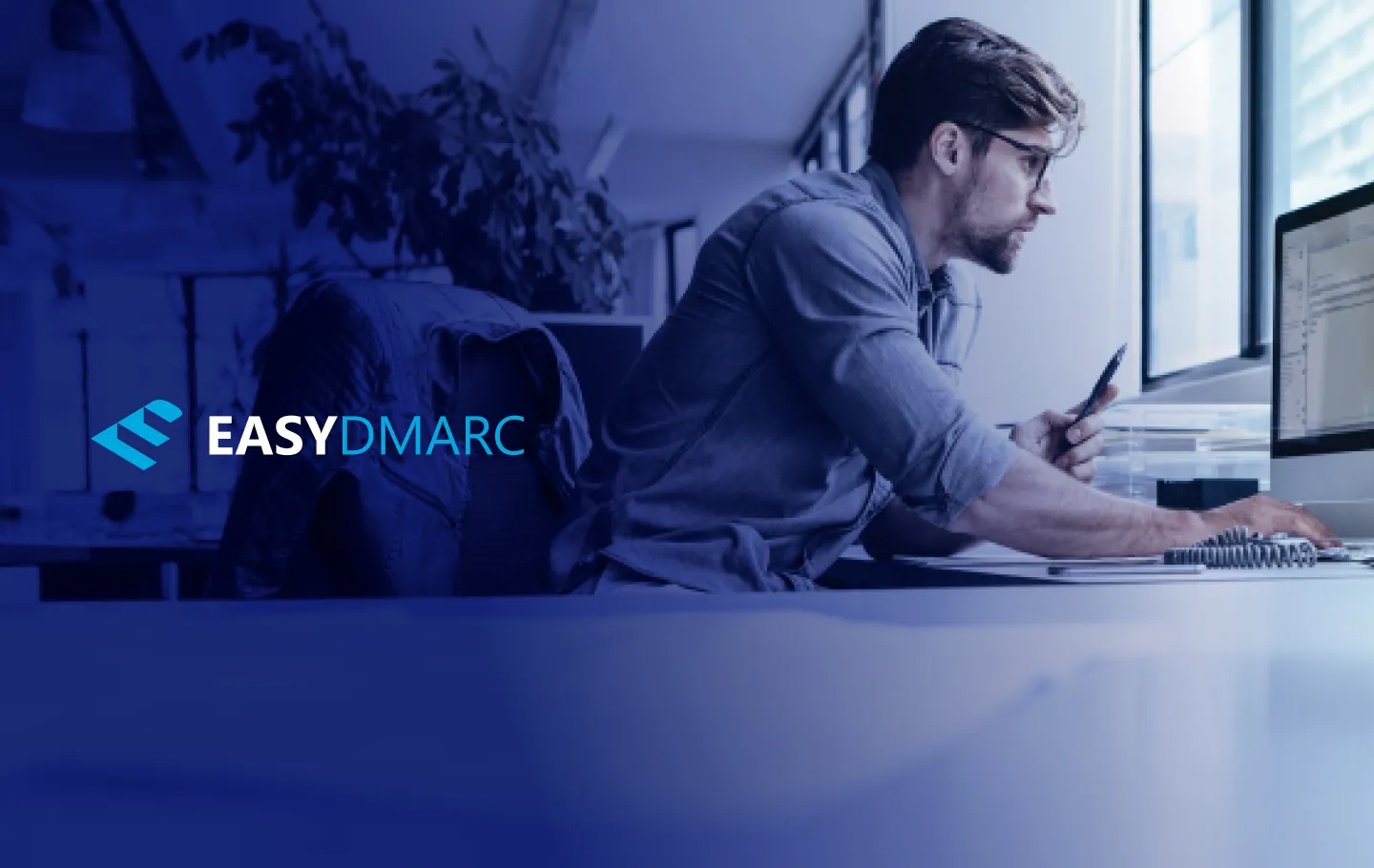 A person working on a computer, EasyDMARC logo on the left side