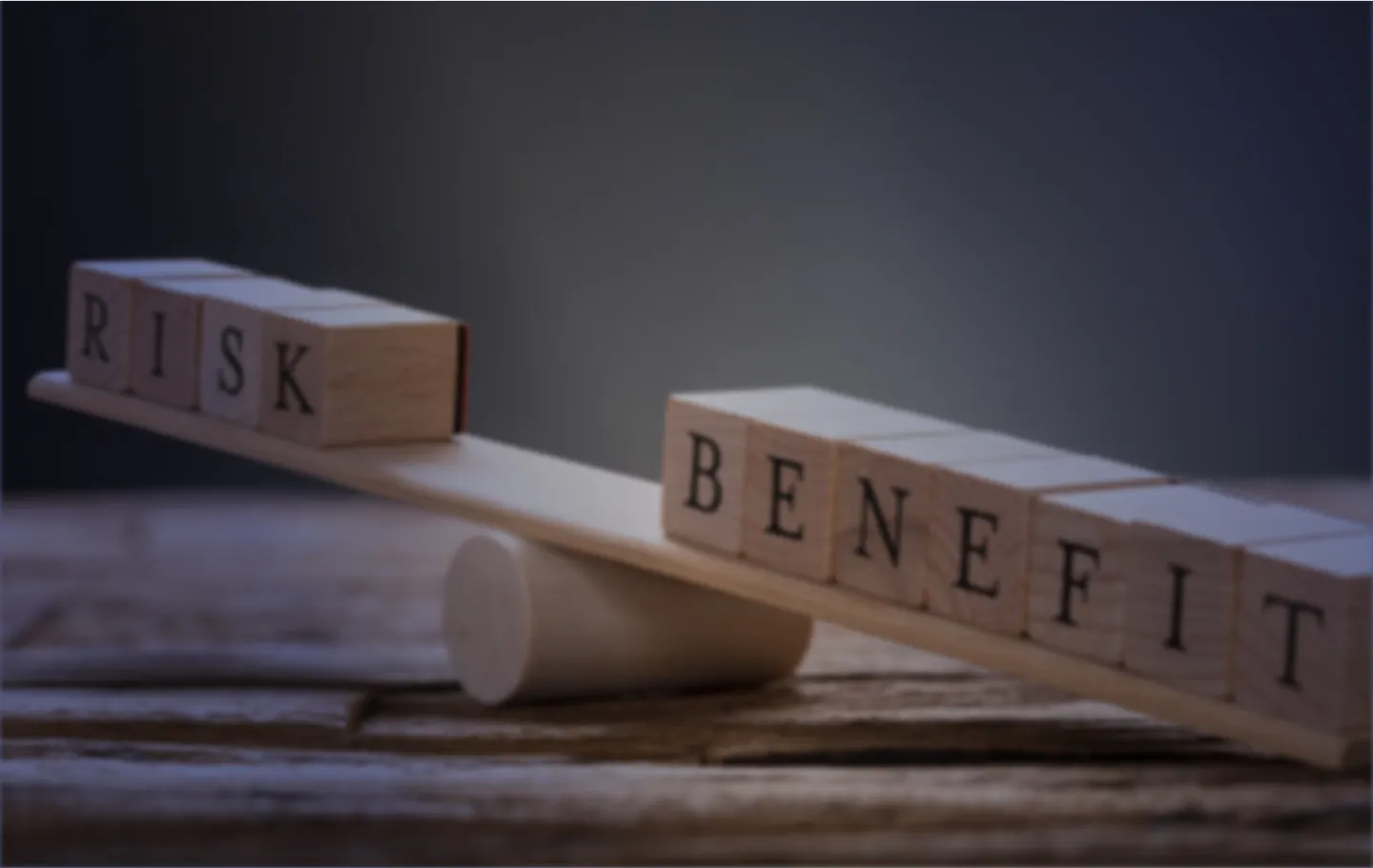 Risk and Benefit written on wooden squares next to each other